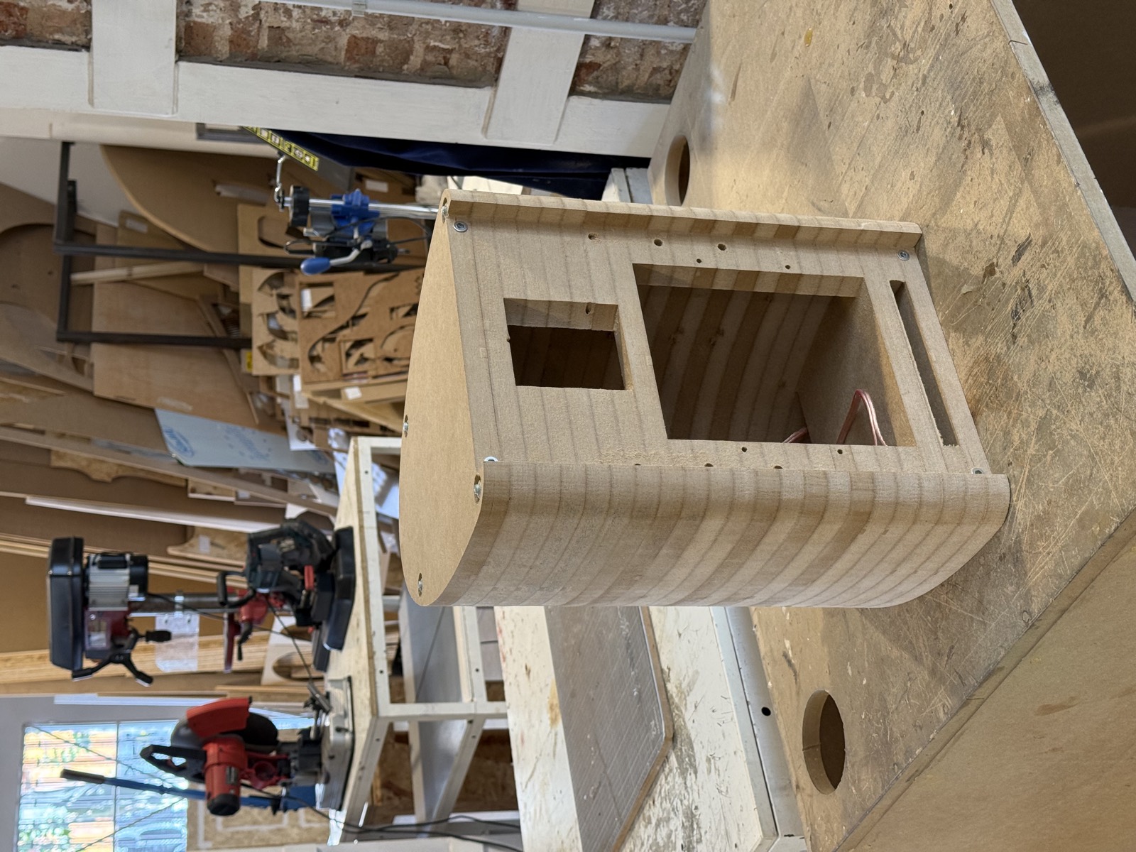El recinto en el banco del taller, entre el resto de piezas mecanizadas por CNC.